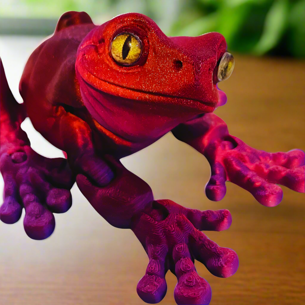 Front view of a 3D printed tree frog in red and purple, featuring large eyes and a detailed texture, showcasing the frog's unique color blend.