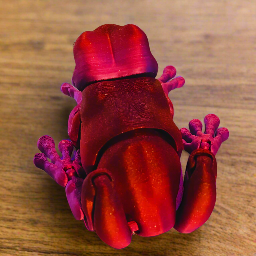 Top view of a 3D printed tree frog in red and purple, showcasing the frog's intricate design and vibrant color scheme.