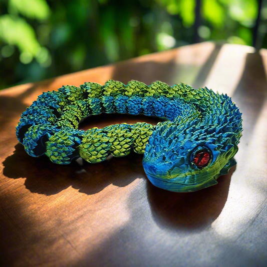 3D printed copperhead snake toy coiled up, displaying its blue and yellow colors and articulating design, 26 inches long.