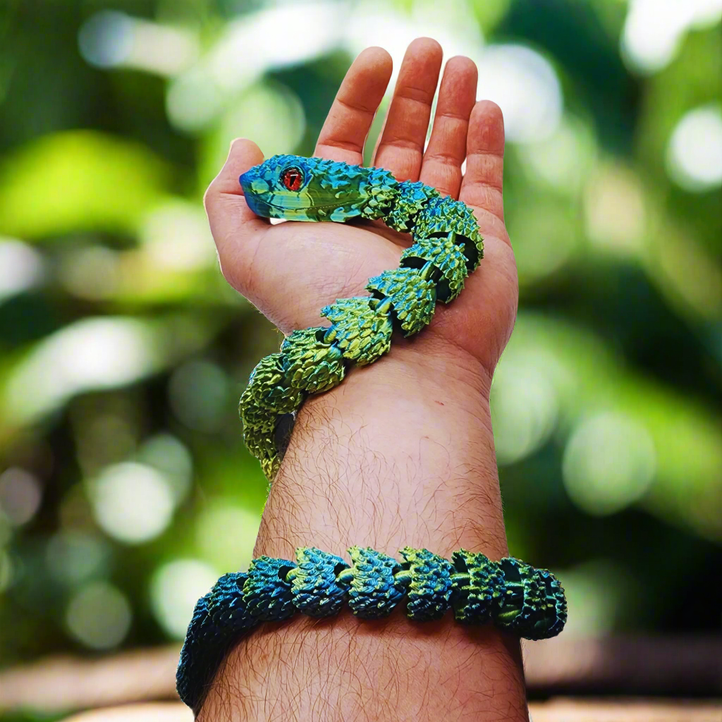 3D printed copperhead snake toy in blue and yellow, wrapped around a person's arm, showing its flexible and articulating design, 26 inches long.