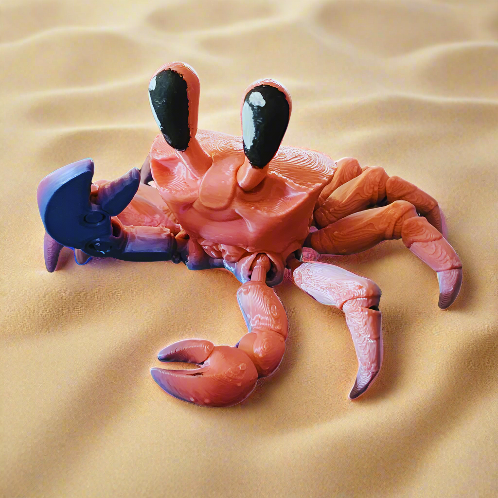 A close-up of the 3D-printed articulated crab’s large black eyes and detailed claws. Set against sand, this fun fidget toy is perfect for collectors and kids, offering flexible movement and vibrant colors.