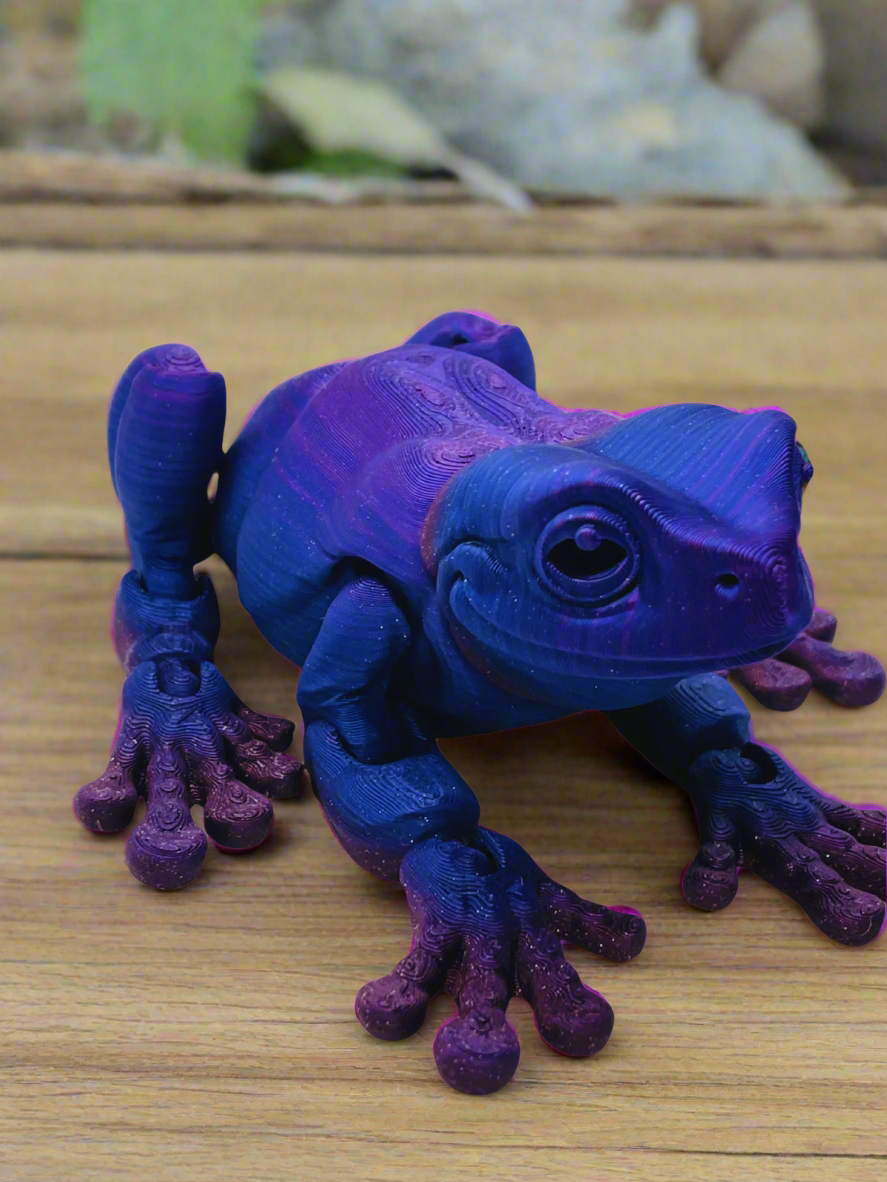 Front view of a 9-inch long 3D printed tree frog in blue and purple, featuring a stretched-out design and no eyes.