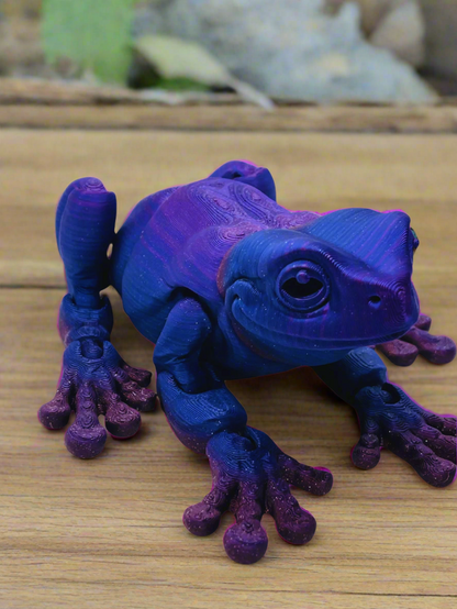 Front view of a 9-inch long 3D printed tree frog in blue and purple, featuring a stretched-out design and no eyes.