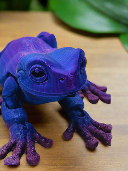 Front view of a 9-inch long 3D printed tree frog in blue and purple, featuring a stretched-out design and no eyes.