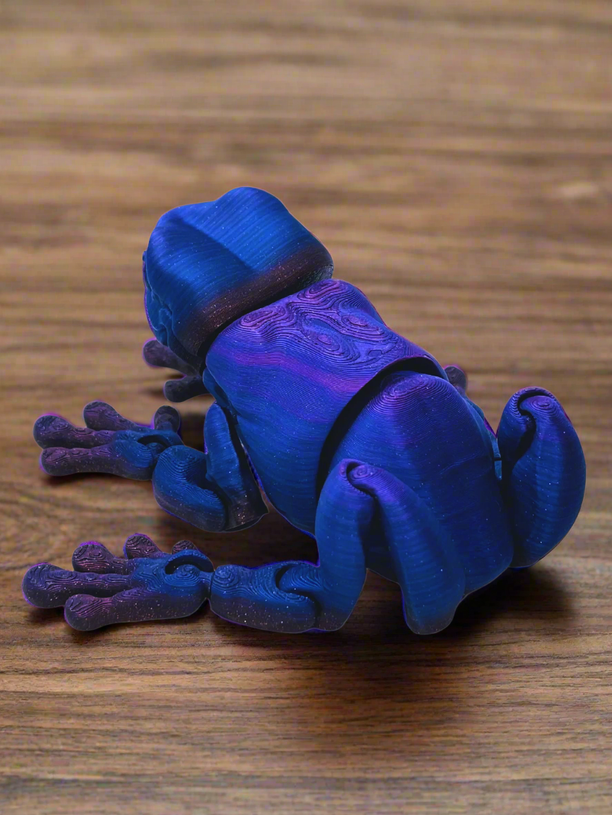 Side view of a 9-inch long 3D printed tree frog in blue and purple, showcasing its unique eyeless design and smooth features.