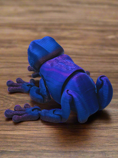 Side view of a 9-inch long 3D printed tree frog in blue and purple, showcasing its unique eyeless design and smooth features.