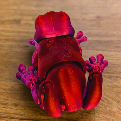Top view of a 3D printed tree frog in red and purple, showcasing the frog's intricate design and vibrant color scheme.