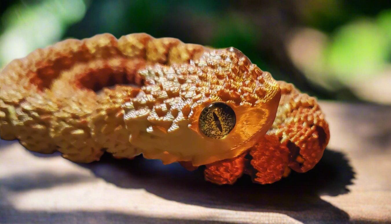 A coiled golden and orange snake figure with a realistic amber eye and highly detailed textured scales.