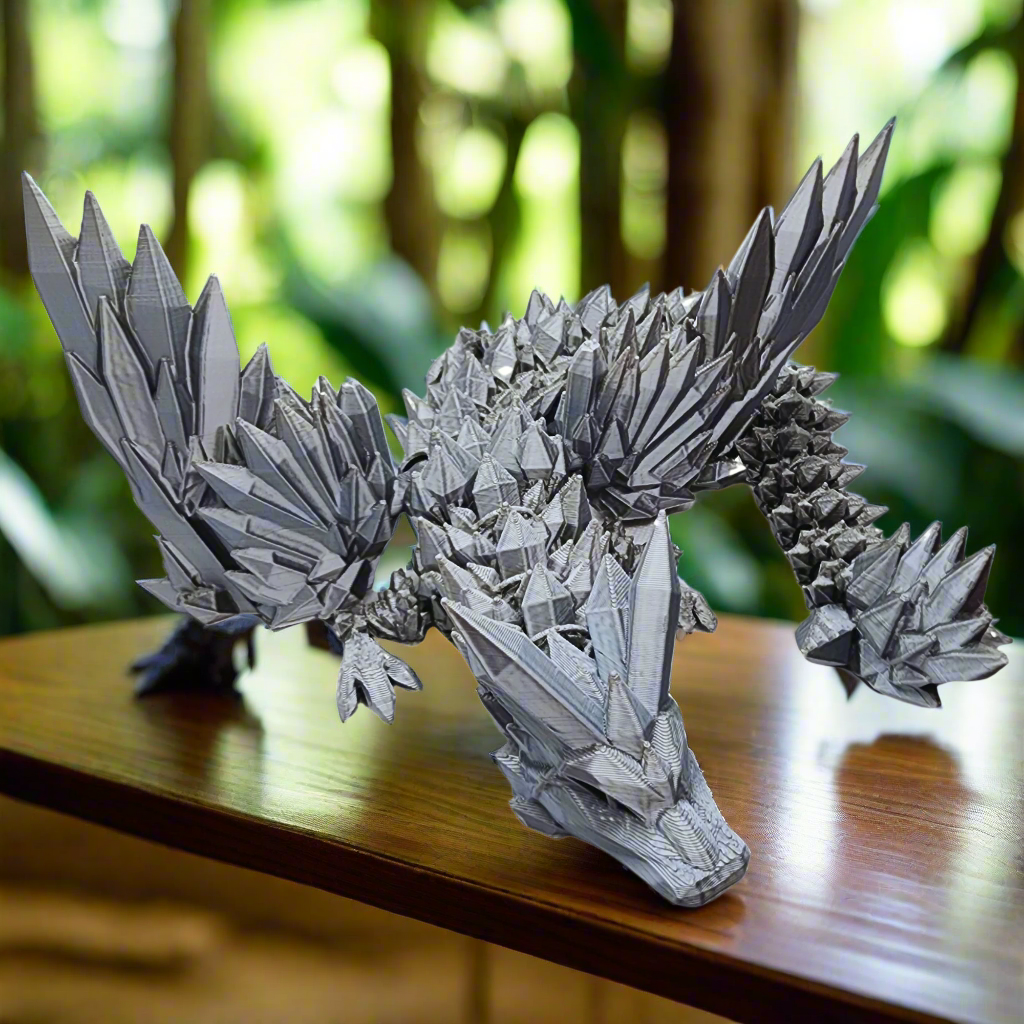 A majestic silver dragon figurine resting on a wooden surface, showcasing its detailed wings and scales.