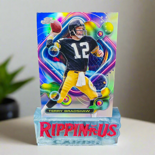 Image of Terry Bradshaw 2023 Topps Composite Cosmic Chrome Refractor card featuring the Pittsburgh Steelers Hall of Fame quarterback in his black and yellow uniform, with a vibrant cosmic refractor design.

